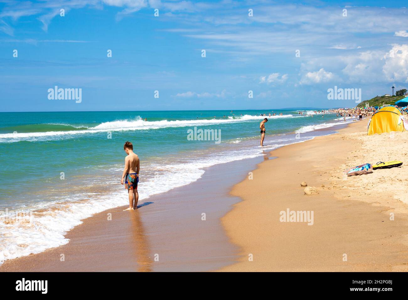 Sunny sandy beach with waves and vacationers. Anapa, Russia-07.07.2021 Stock Photo