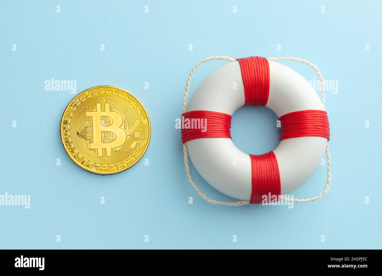 Gold bitcoin coin and lifebuoy on a blue background. Concept to help you buy  cryptocurrencies Stock Photo - Alamy