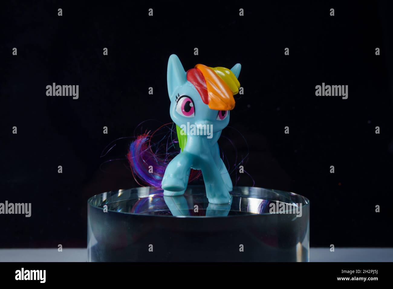 colorfull toy pony horse on the glass cylinder the color background Stock Photo