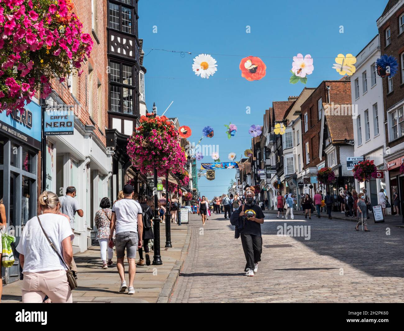 Guildford High Street shops with shoppers some wearing face masks
