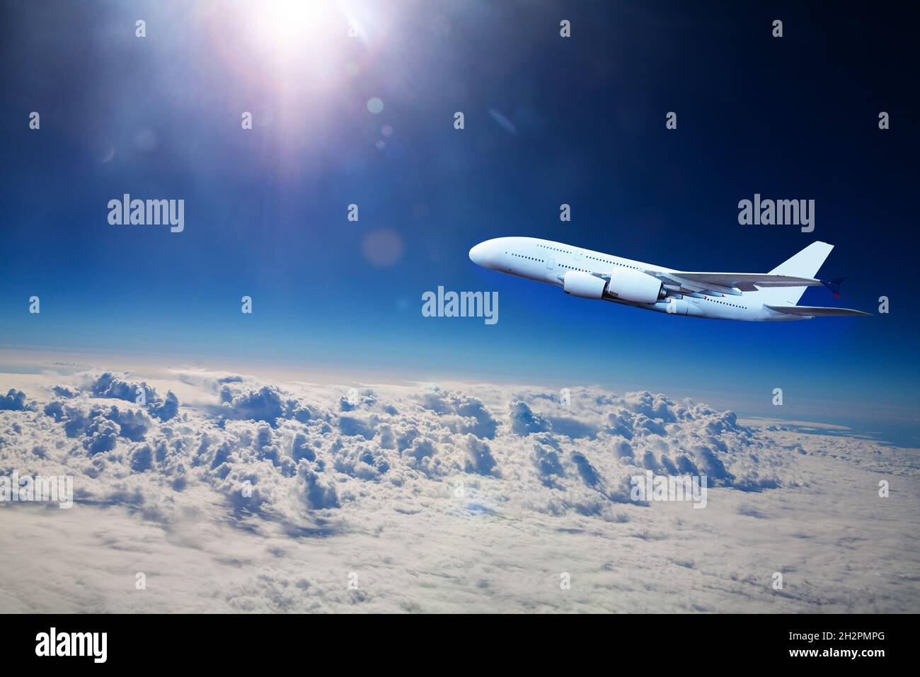 Big jet plane fly above clouds at high altitude Stock Photo