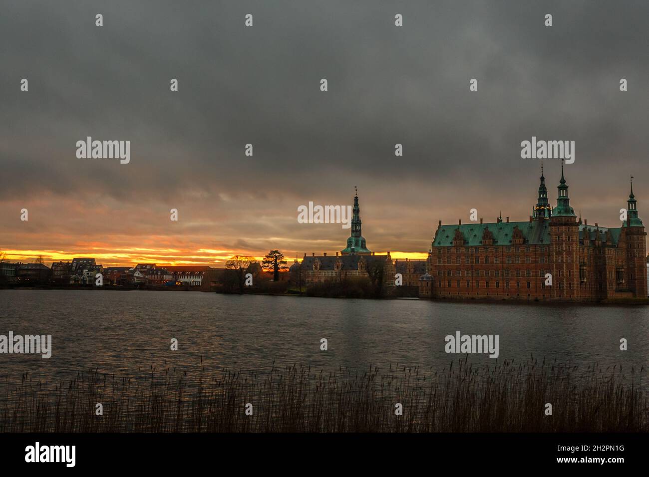 Frederiksborg castle on the sunset, with lake and tree in the foreground, Hillerod, Denmark Stock Photo