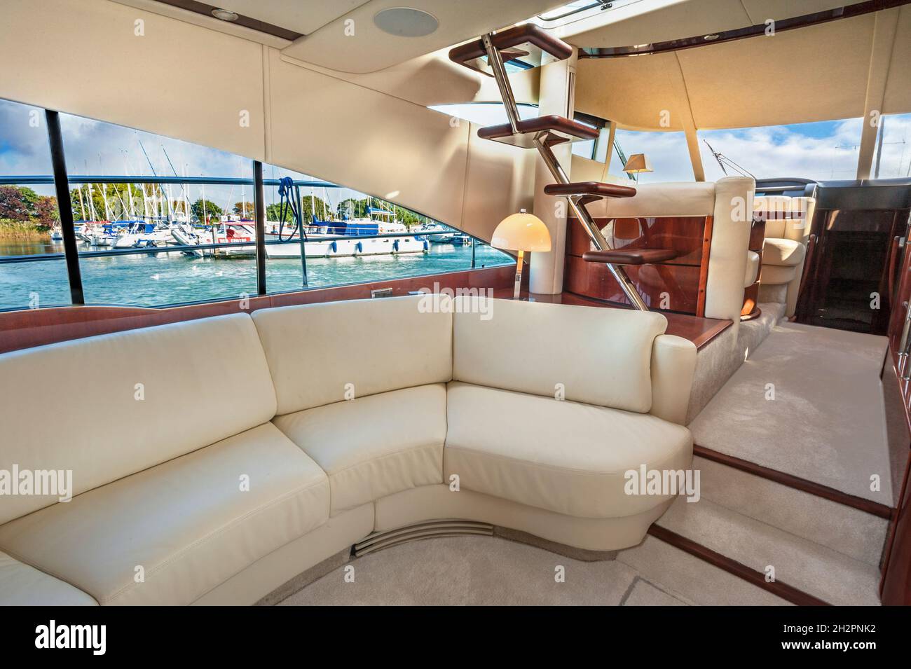 Princess 50 luxury motor yacht interior, with cream leather seating, leading to the carpeted front of the yacht with the captains steering and engine controls area and stairs to the flybridge Stock Photo