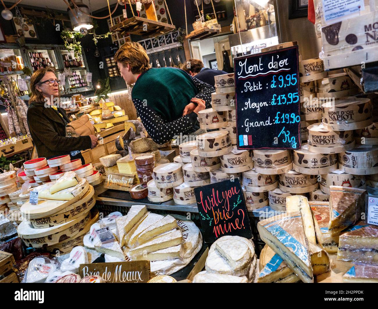 French cheese market stall display Borough Market with wide selection of French regional cheeses including Mont d’Or and Brie cheese varieties  in Borough Market Southwark London UK Stock Photo