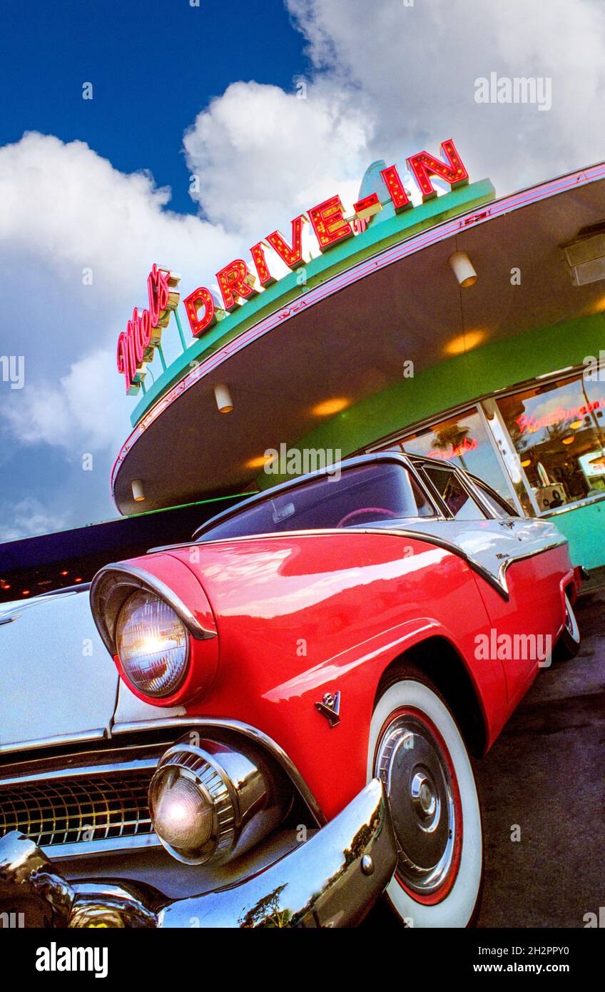 AMERICAN RETRO DRIVE IN DINER EATERY with Classic 1955 Ford Fairlane car parked outside trendy American retro Mel's drive-in diner eatery restaurant Florida USA Vertical Portrait Exterior Outside 1950’s classic car diner drive-in two-tone red white chrome white wheels American car Americana Fast food Fast cars chrome Bygone era Rock and roll Drive through Mel’s Diner Stock Photo