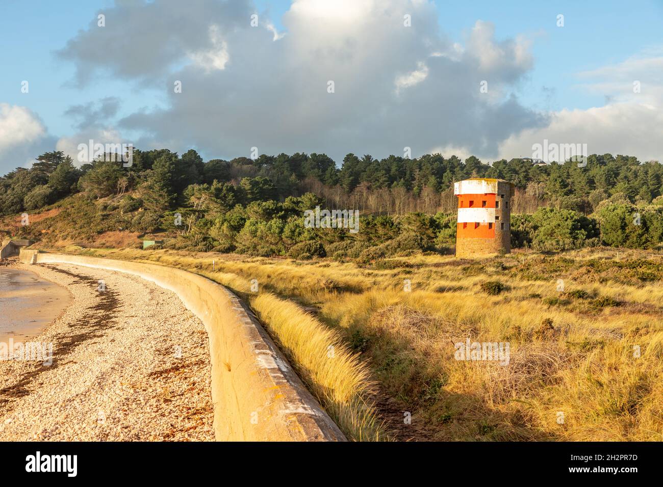 Saint Brelade British round coastal defence tower standing on the coast with German defence barrier, bailiwick of Jersey, Channel Islands Stock Photo