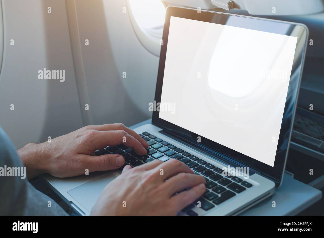 passenger using laptop computer in airplane, onboard wifi