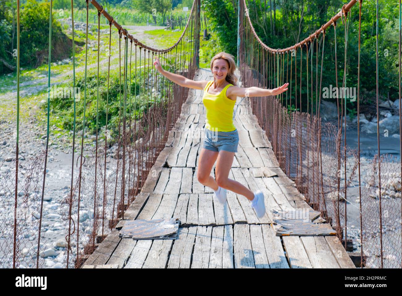 one woman jumping on a suspension bridge in Stock Photo Alamy
