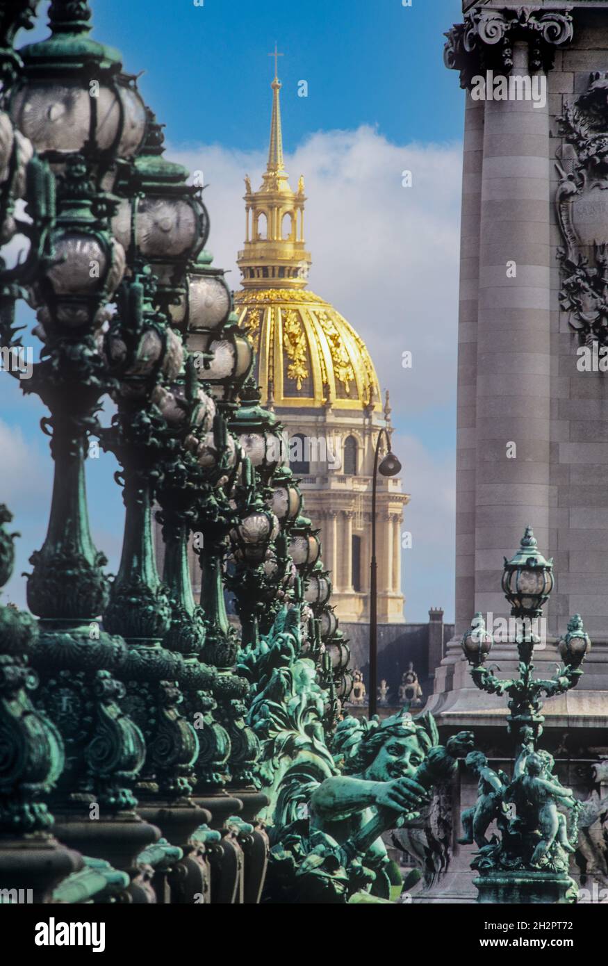 PONT ALEXANDRE Art Nouveu ornate lamps along Pont Alexandre III (bridge) over the Seine river in Paris with gold dome of Hotel des Invalides beyond, Paris France Stock Photo