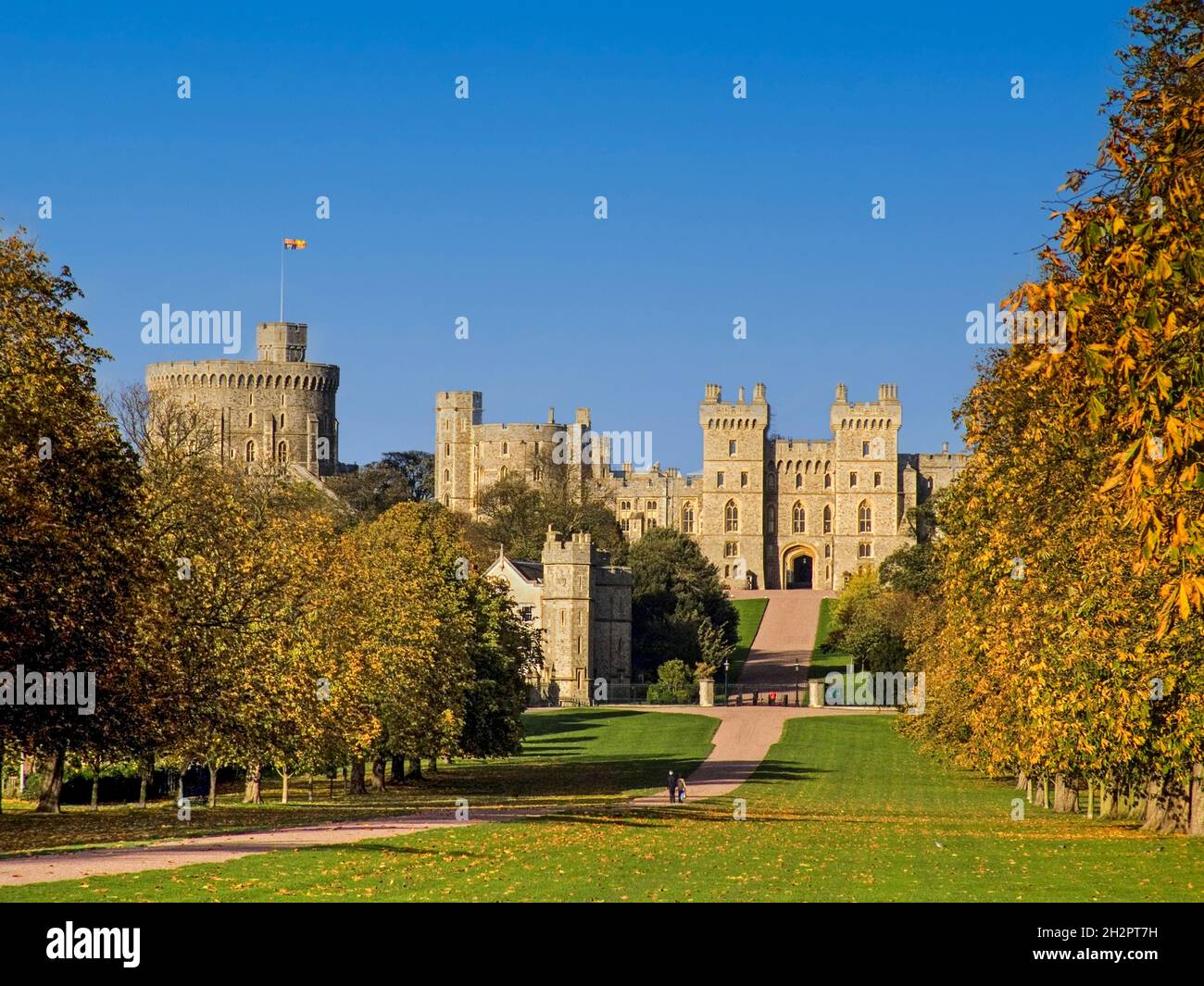 Windsor Castle flying Royal Standard viewed down the Long Walk with walkers, in autumnal colour Berkshire UK Stock Photo