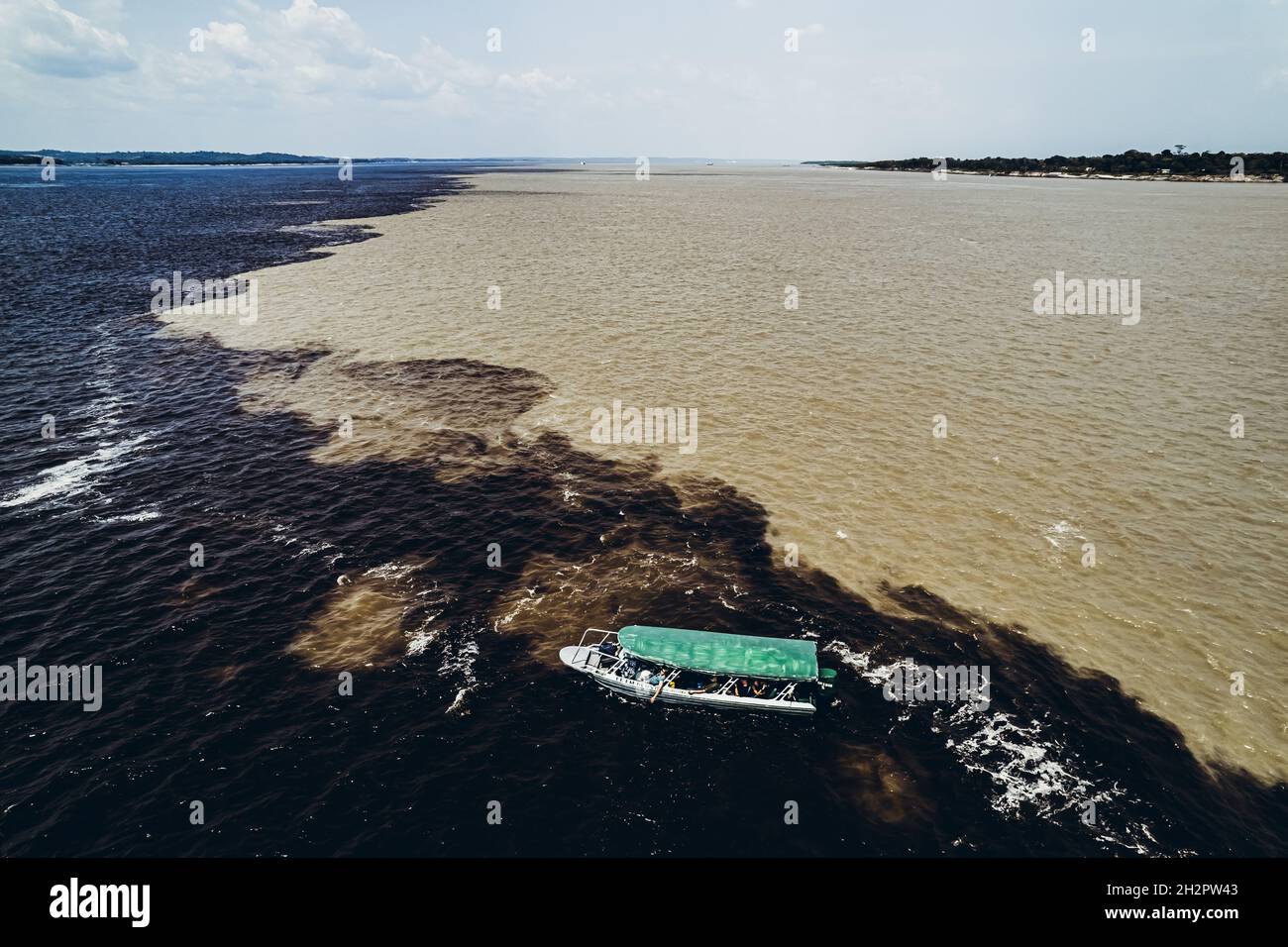 Boat with tourists on the verge of mixing rivers. Amazon Stock Photo Alamy