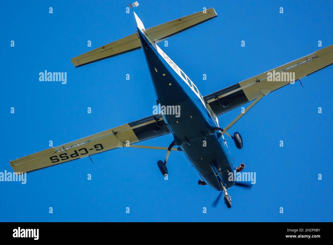 cose up of Cessna 208b Grand Caravan G-CPSS light aircraft flies low over head just after taking off with parachutists on board Stock Photo