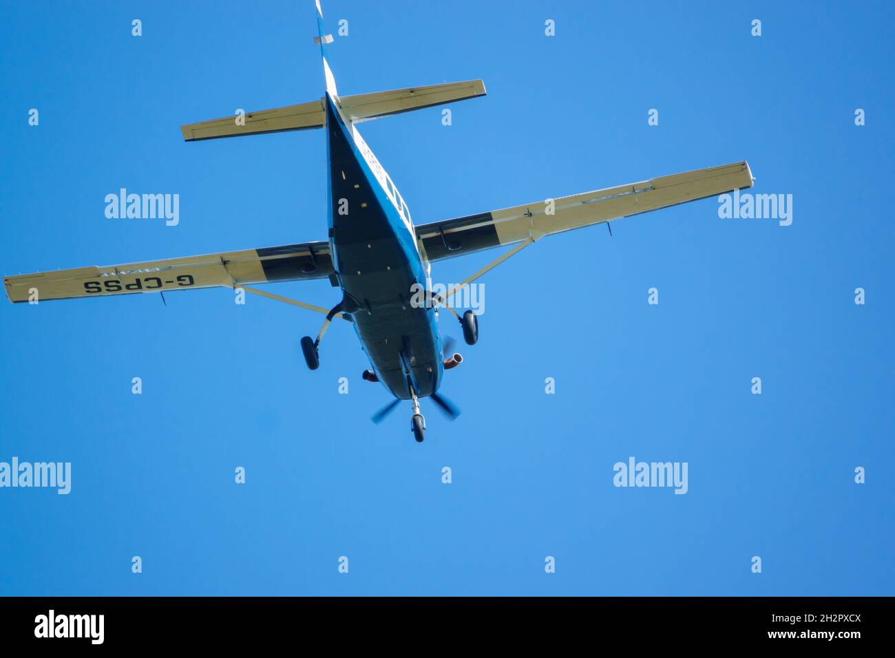 cose up of Cessna 208b Grand Caravan G-CPSS light aircraft flies low over head just after taking off with parachutists on board Stock Photo