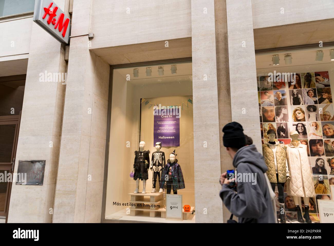 People pass in front of a shop window prepared for Halloween of H&M  clothing store in Valencia Stock Photo - Alamy