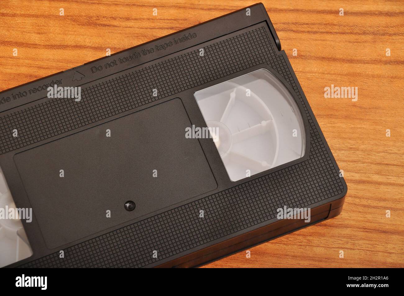 Old blank vhs analog video cassette tape isolated on wood background