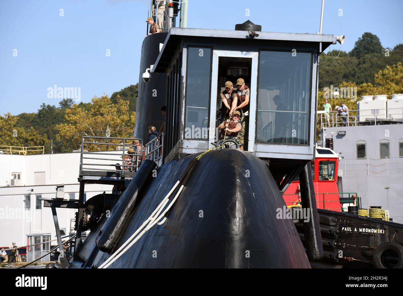 Groton, United States. 15 October, 2021. U.S. Navy sailors pull a mooring line from the pier to the Historic Ship USS Nautilus as the ship prepares to be moored at Submarine Base New London October 15, 2021 in Groton, Connecticut. Nautilus, was the first nuclear-powered submarine and current Submarine Force Museum centerpiece, and will begin an $36-million dollar preservation project. Credit: CPO Joshua Karsten/U.S. Navy/Alamy Live News Stock Photo