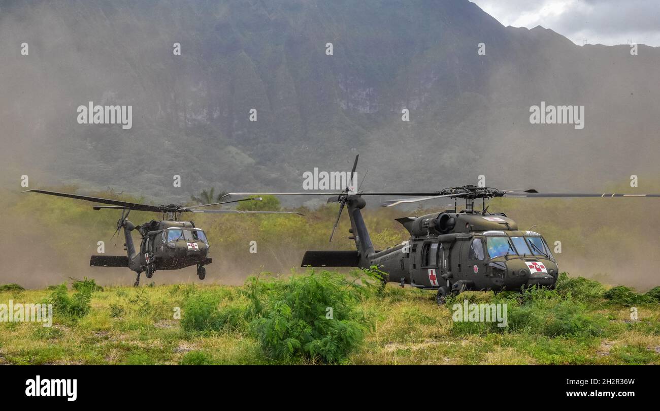 Hawaii Army National Guard (HIARNG) Soldiers with 3rd Battalion, 126th and 1st Battalion, 189th Aviation Regiments prepare to land the UH-60M Black Hawk aircraft after returning from a Medical Evacuation (MEDEVAC) during helicopter hoist training, Wahiawa, Hawaii, June 17, 2021. Operational training like this assist Soldiers with certifying their special skills while performing multiple MEDEVAC procedures during an air rescue emergency situation. (U.S. Army National Guard photo by Sgt. 1st Class Theresa Gualdarama) Stock Photo