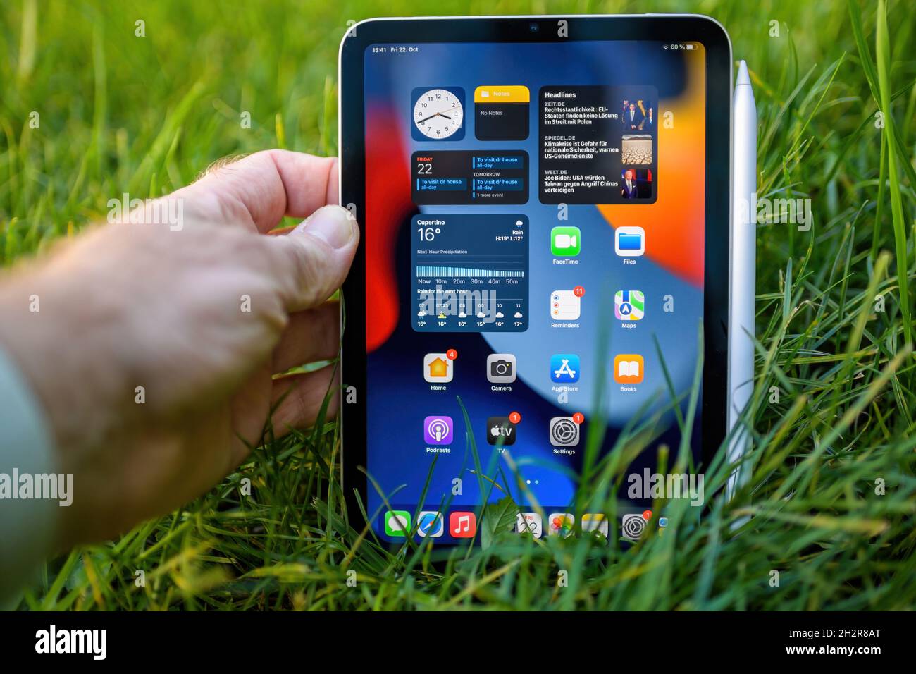 Male hand holding latest Apple Computers iPad Mini stylish compact ...
