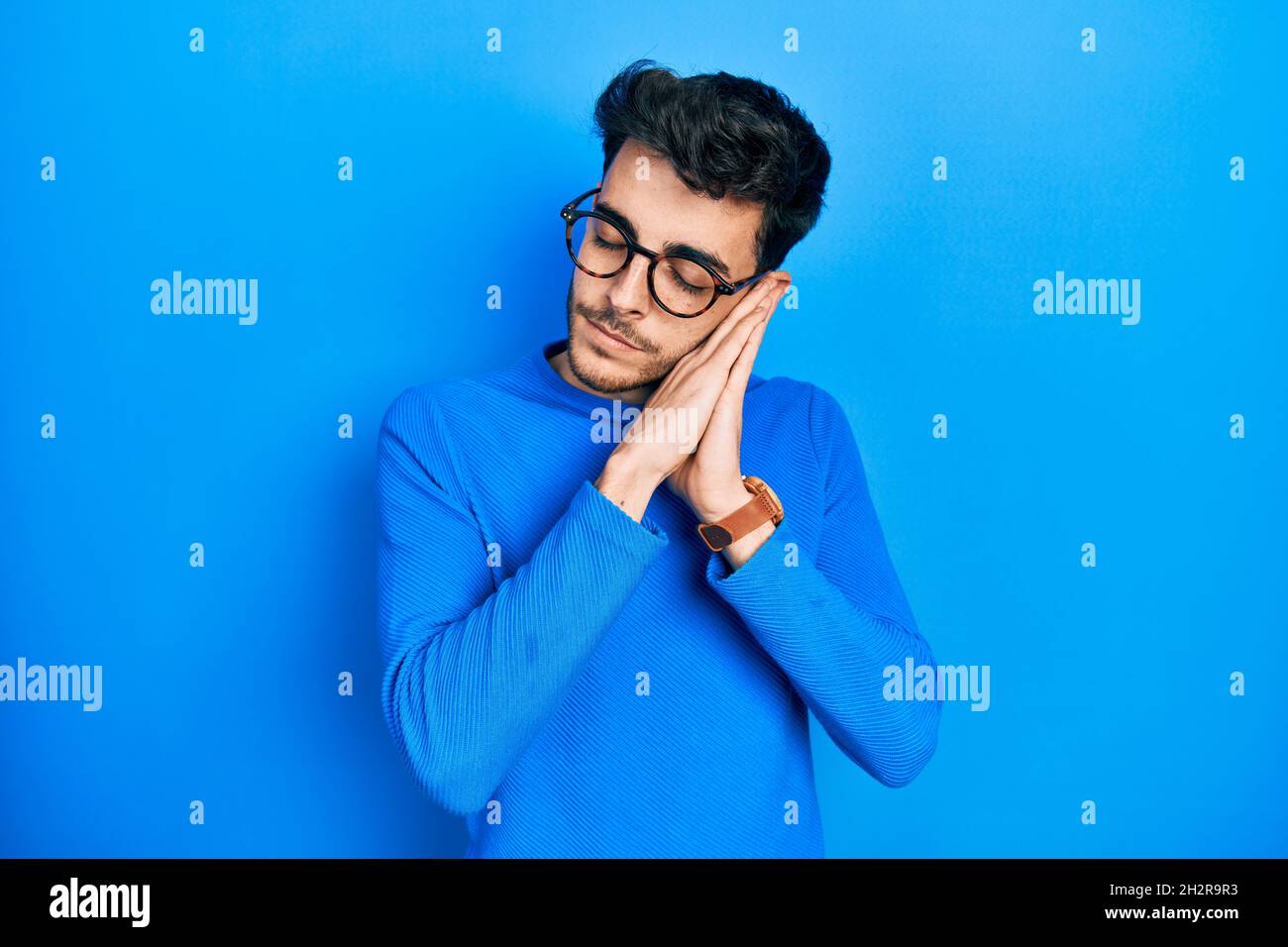 Young hispanic man wearing casual clothes and glasses sleeping tired ...