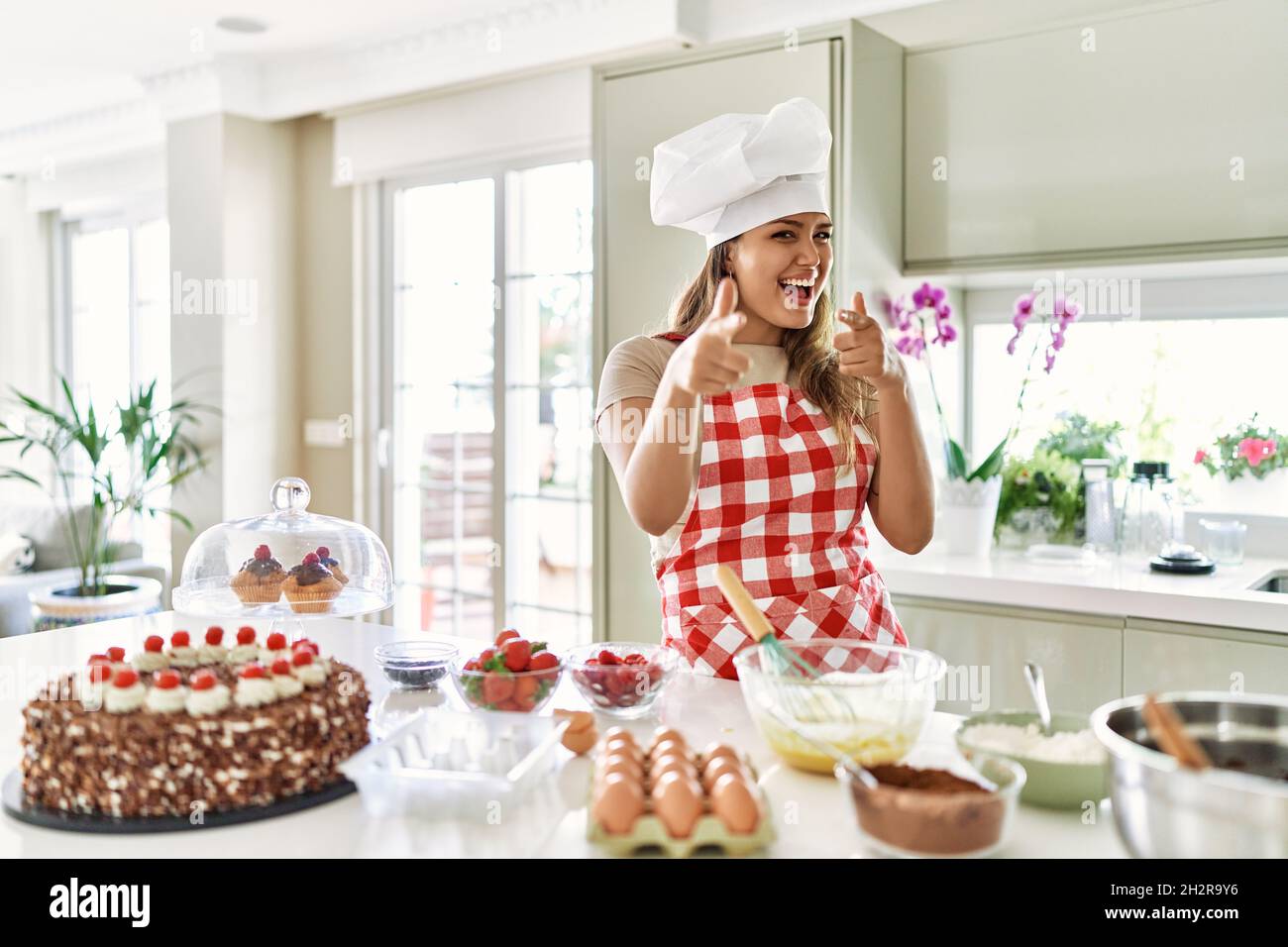 Beautiful young brunette pastry chef woman cooking pastries at the