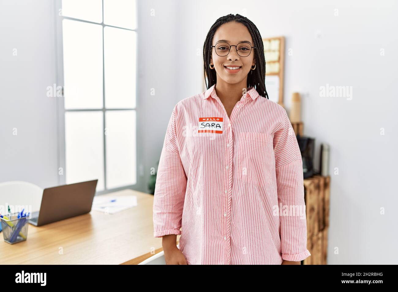 Young african american woman wearing hello my name is sticker ...