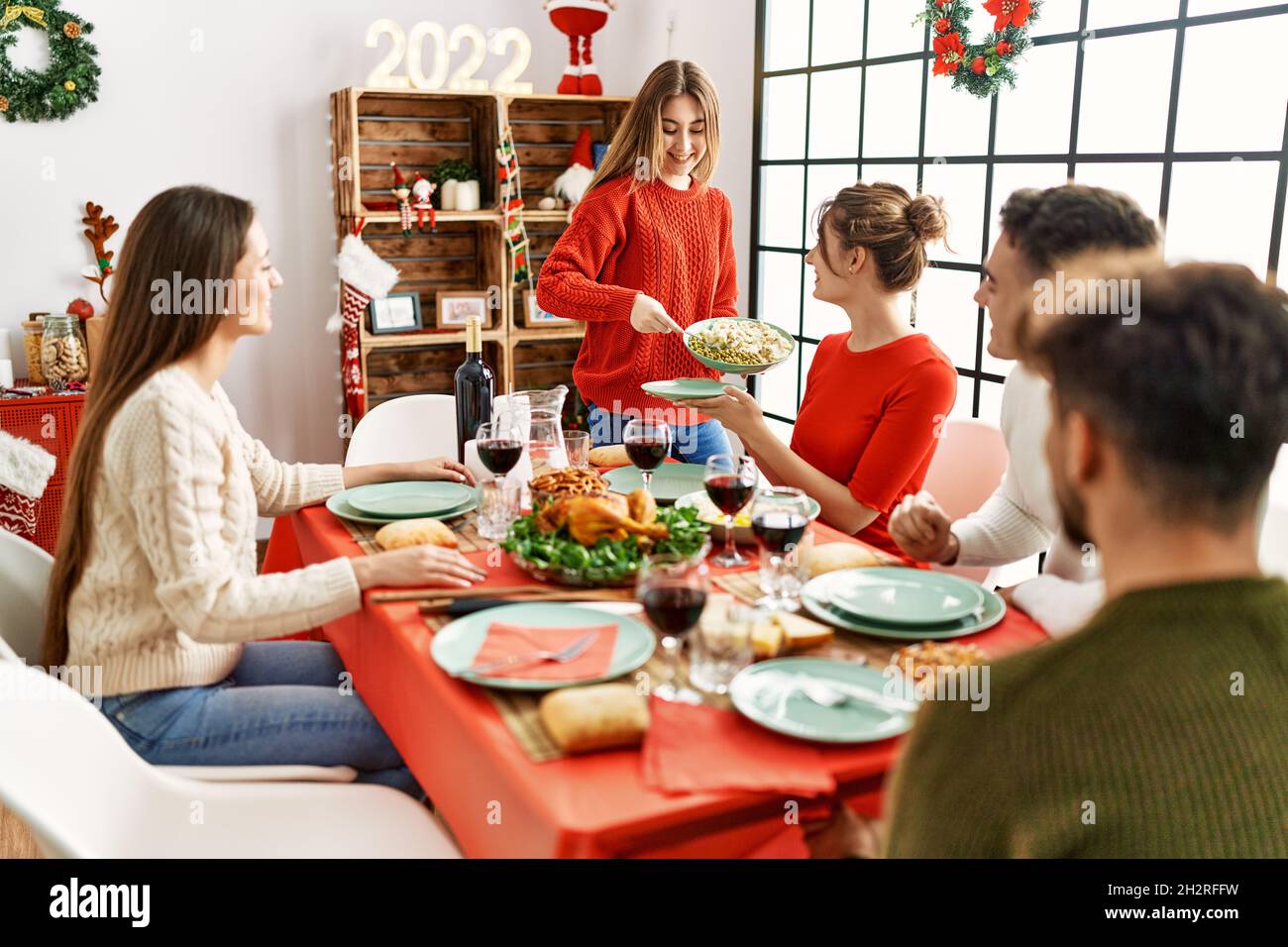 Group of young people smiling happy having christmas dinner at home