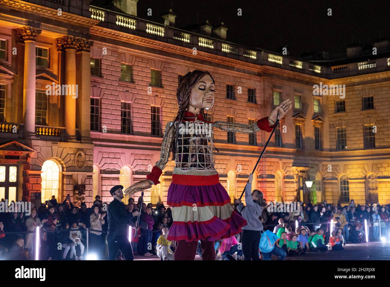 London, UK. 23rd Oct, 2021. Little Amal seen dancing outside the Somerset House.Little Amal is a 3.5 metre-tall puppet representing a Syrian refugee child, whose journey began close to the Turkish-Syrian border, travelling 8,000 km across Europe to the UK in support of refugees. Credit: SOPA Images Limited/Alamy Live News Stock Photo