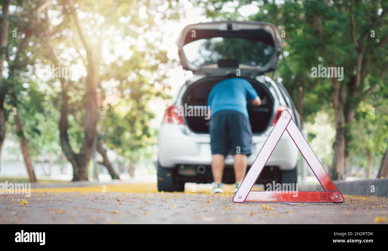 Asian man find tools in the car for car repair after a car breakdown on street. Concept of
