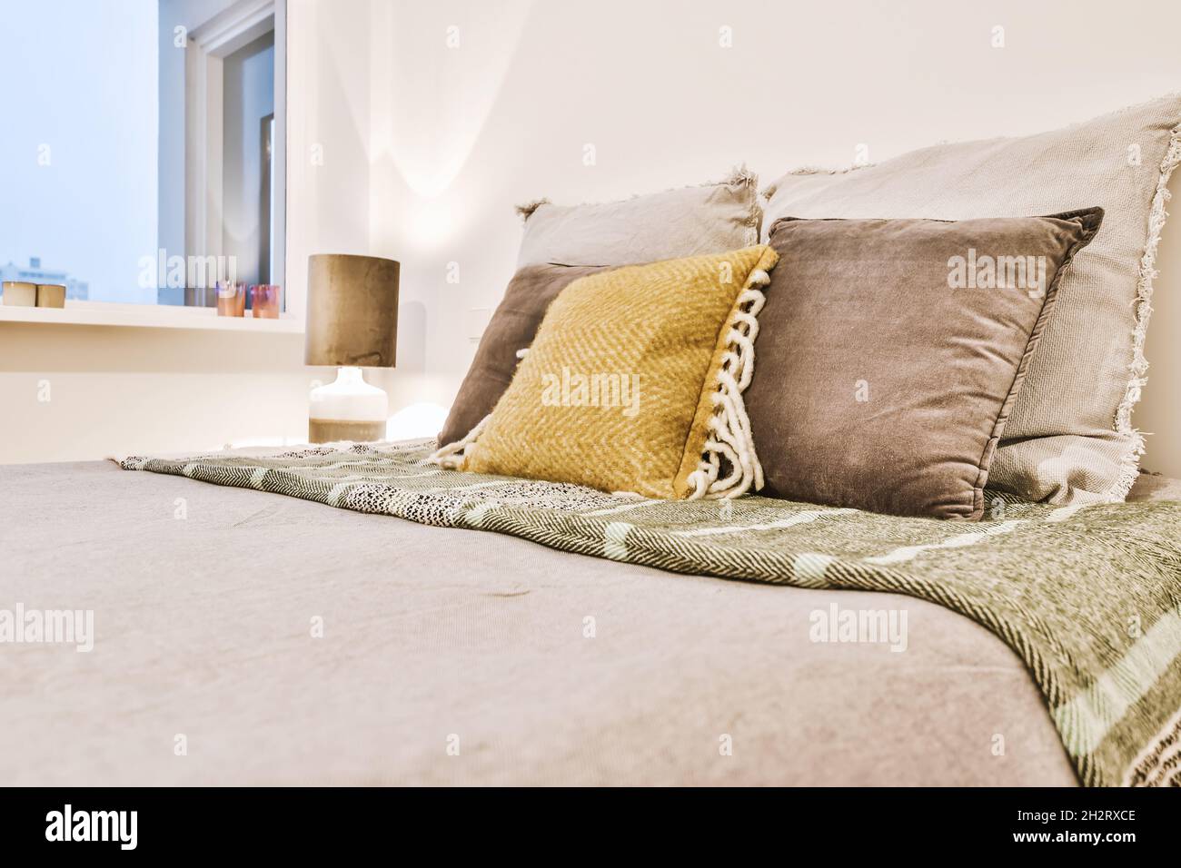 Stylish decor of the bed with decorative pillows Stock Photo