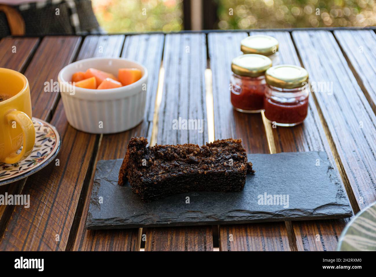 Cookie cake on a slate board, next to assorted jams and papaya. Stock Photo