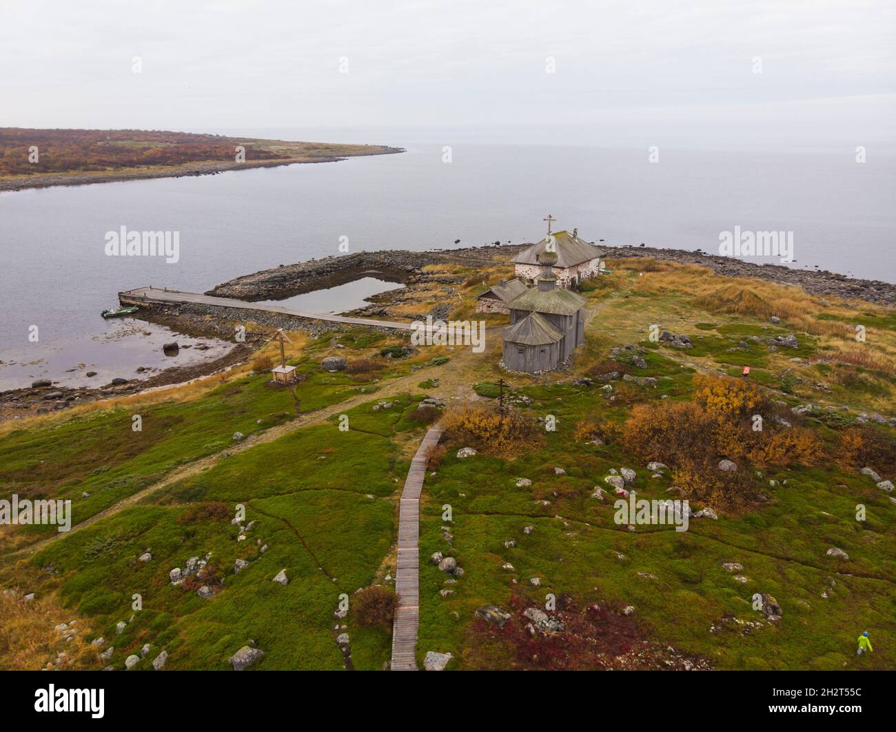 View of the hermitage of St. Andrew the First-Called on Solovki. Big Zayatsky Island. Stone harbor and wooden church Stock Photo