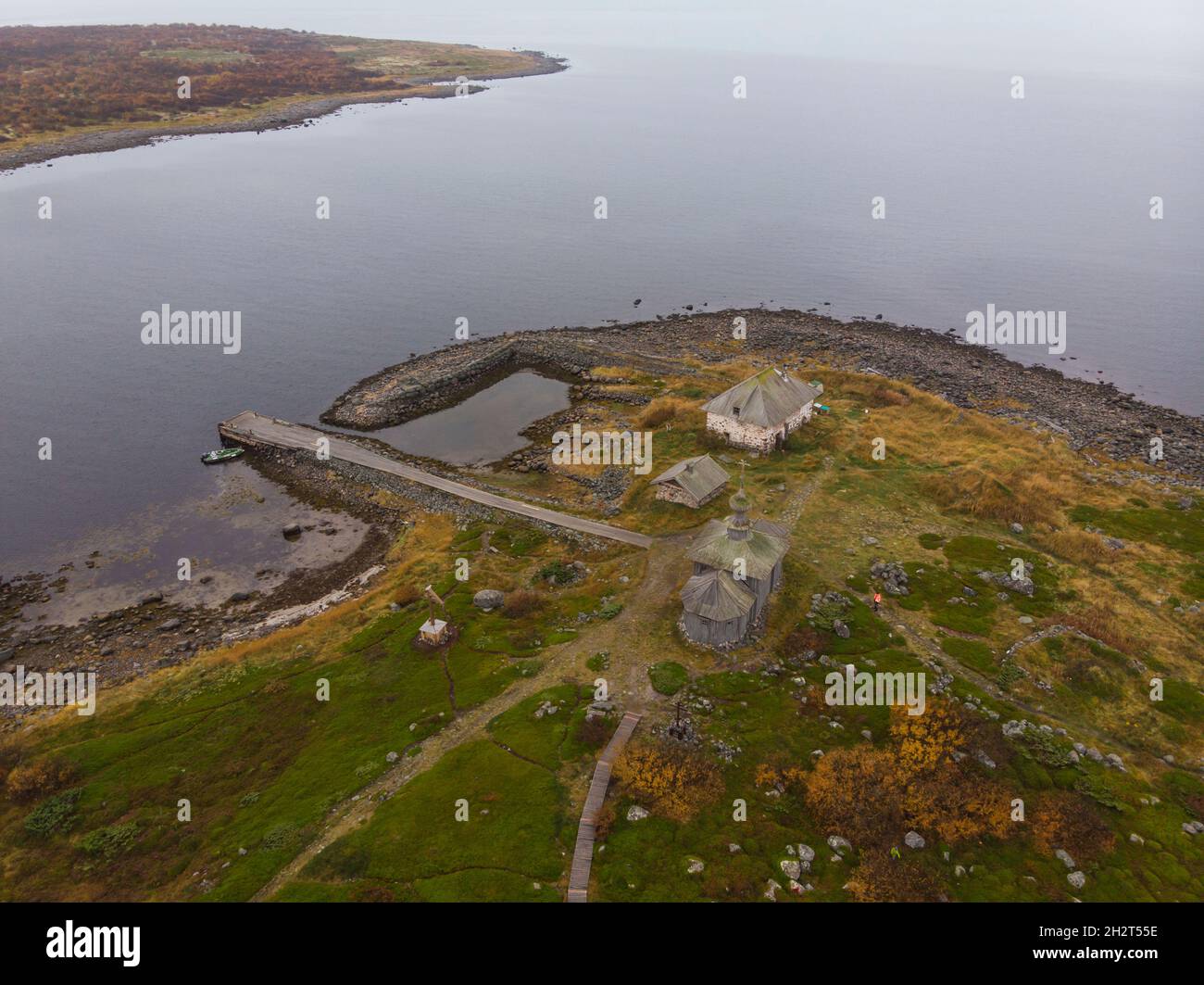 View of the hermitage of St. Andrew the First-Called on Solovki. Big Zayatsky Island. Stone harbor and wooden church Stock Photo