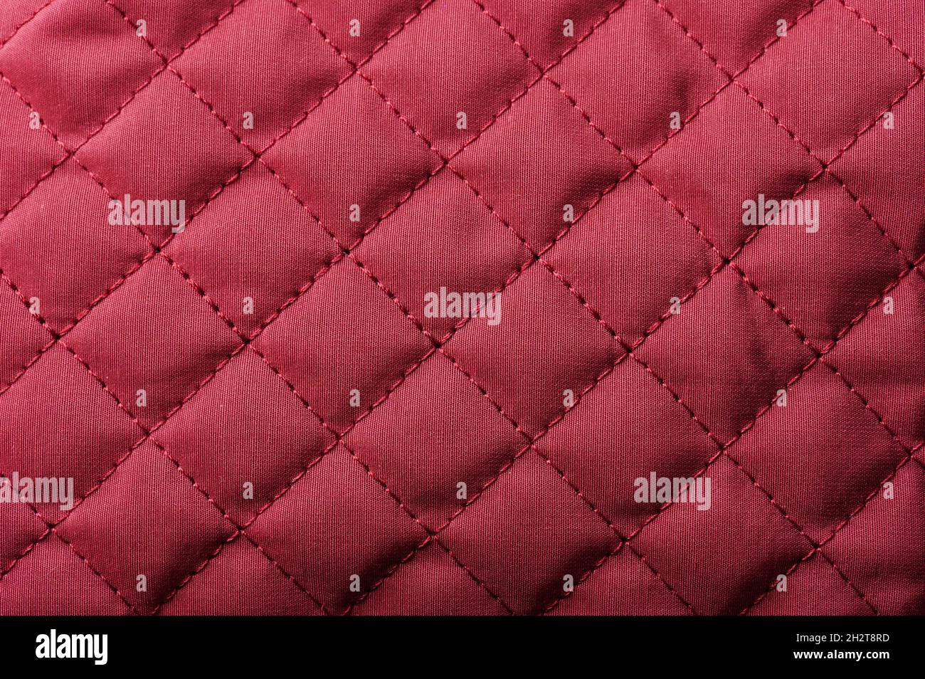 Red  tufted fabric material close up background with stitches Stock Photo