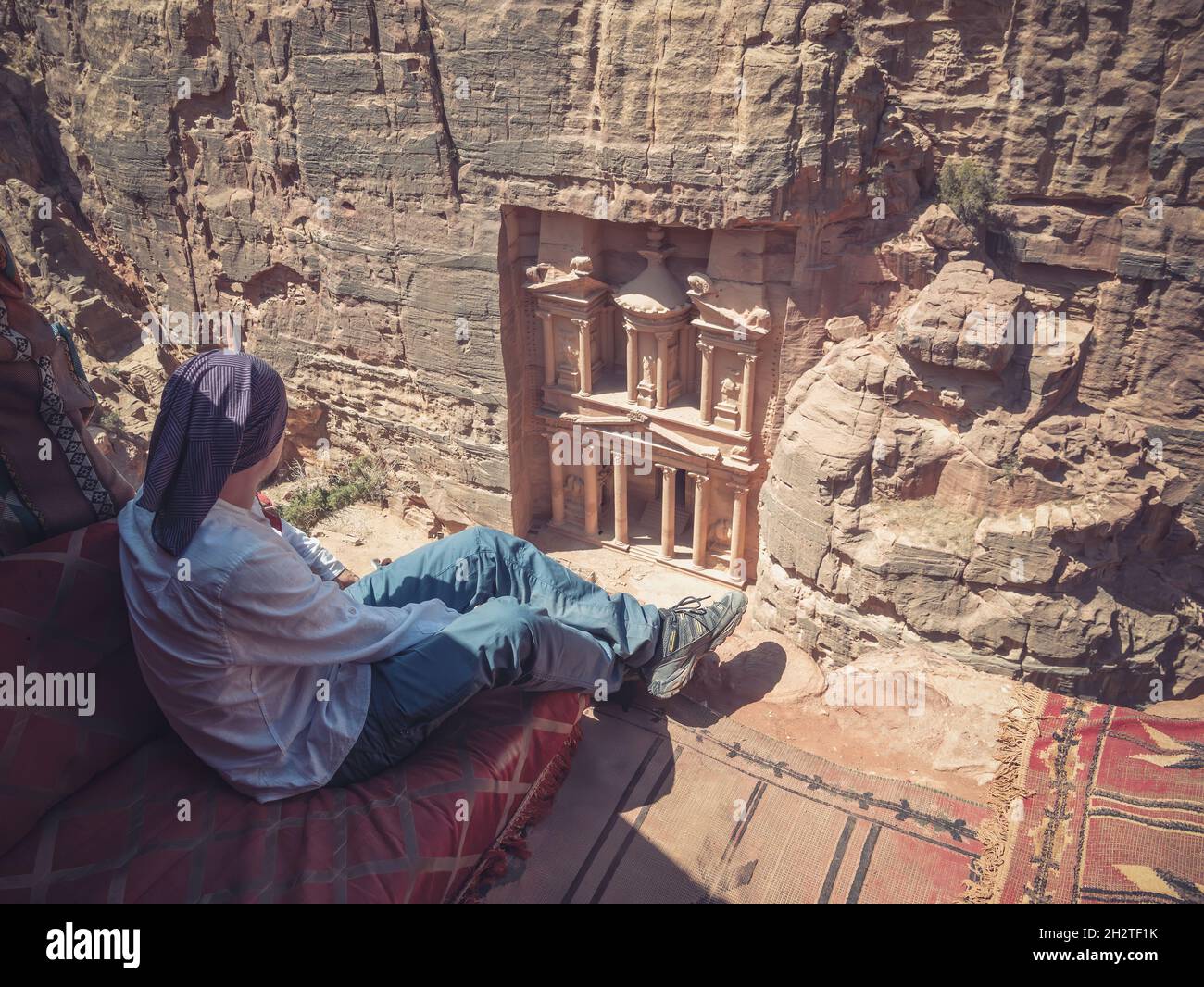 Tourist looking at the The Treasury (Al-Khazneh) from Al-Khubtha Trail Viewpoint Stock Photo