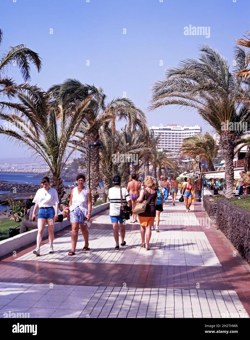 Holidaymakers walking along the promenade, Playa de las Americas, Tenerife,  Spain Stock Photo - Alamy
