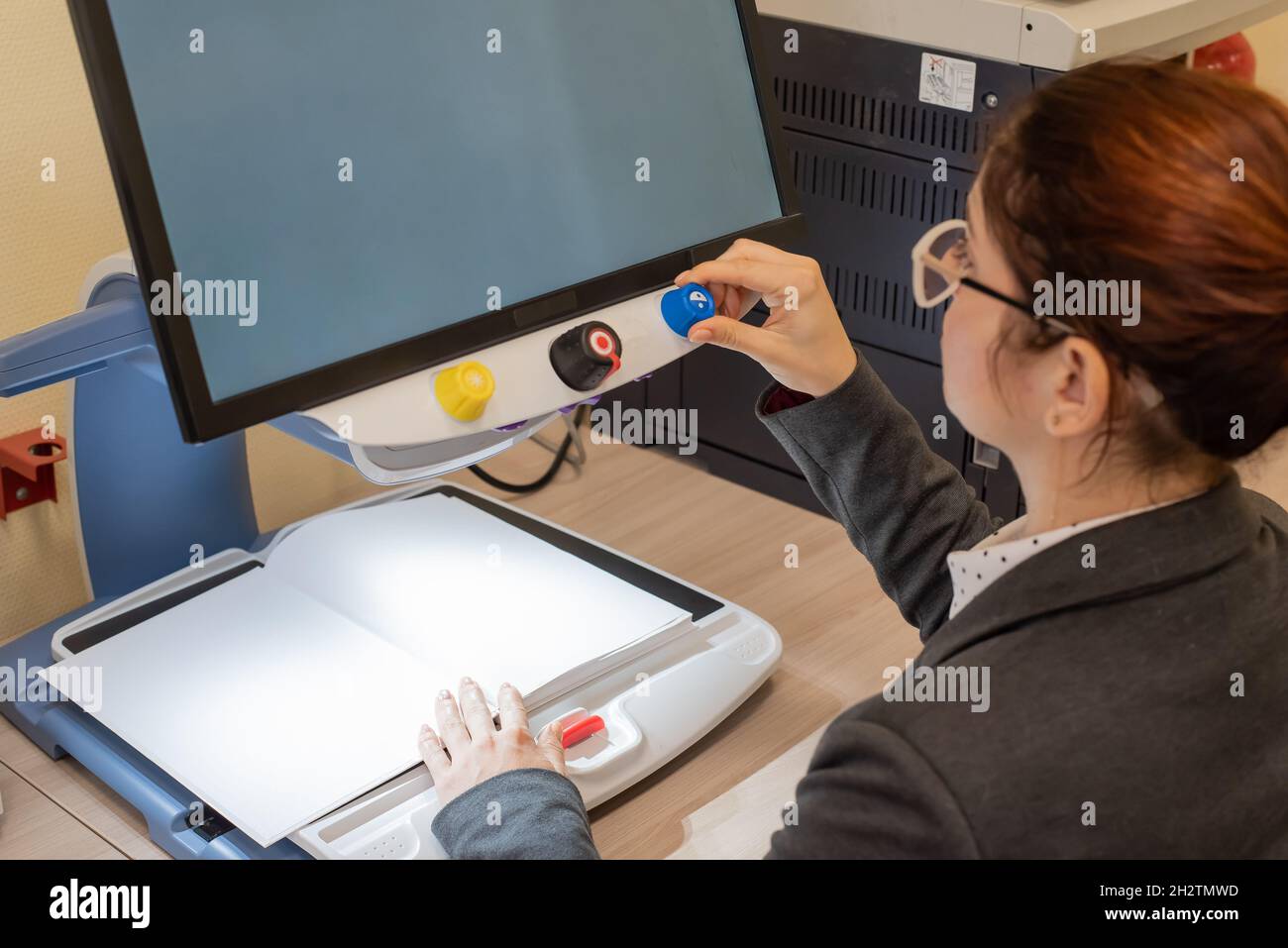 A visually impaired woman uses special reading equipment Stock Photo