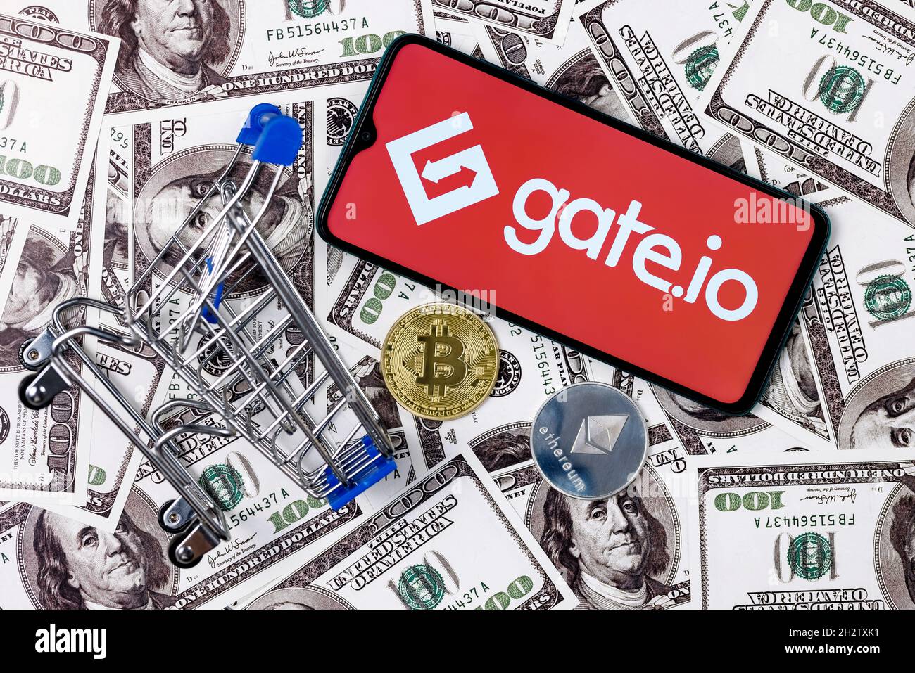 Gate.io is a cryptocurrency exchange. A smartphone with the Gate.io logo, a  shopping cart and a cryptocoins on the dollar bills Stock Photo - Alamy