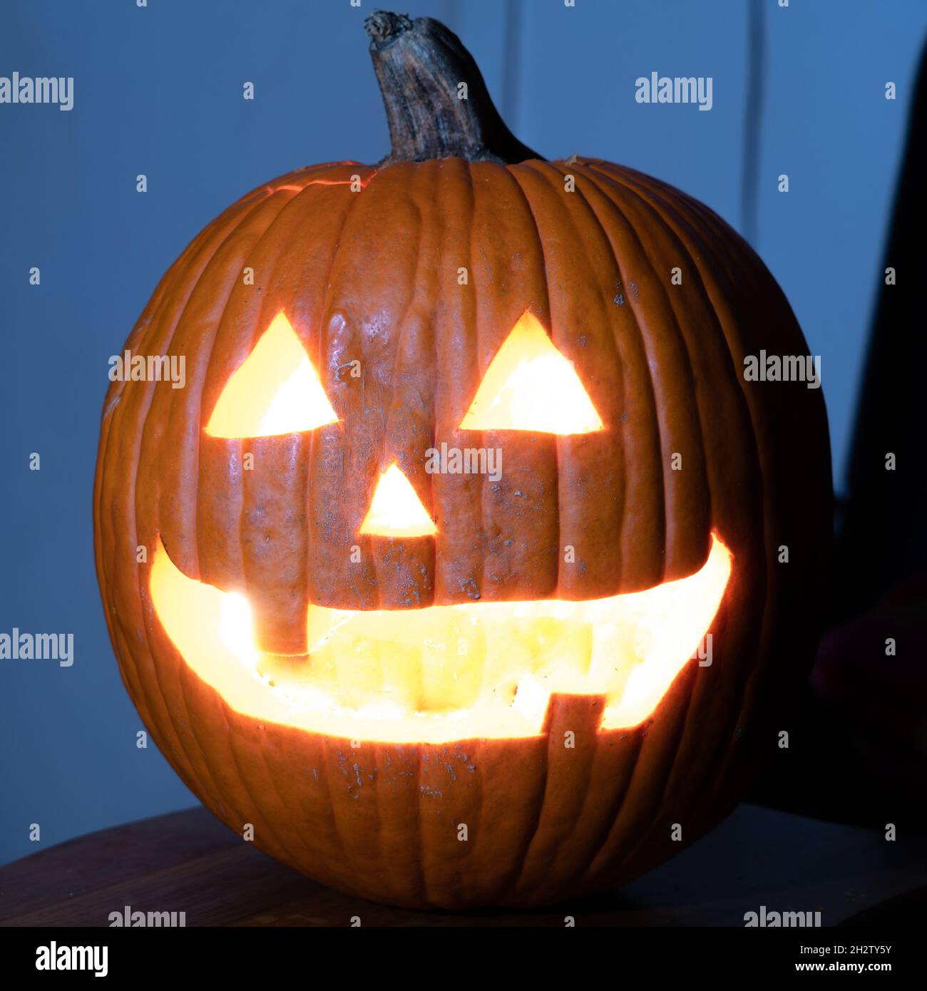 A closeup shot of a jack-o'-lantern in a dark room Stock Photo