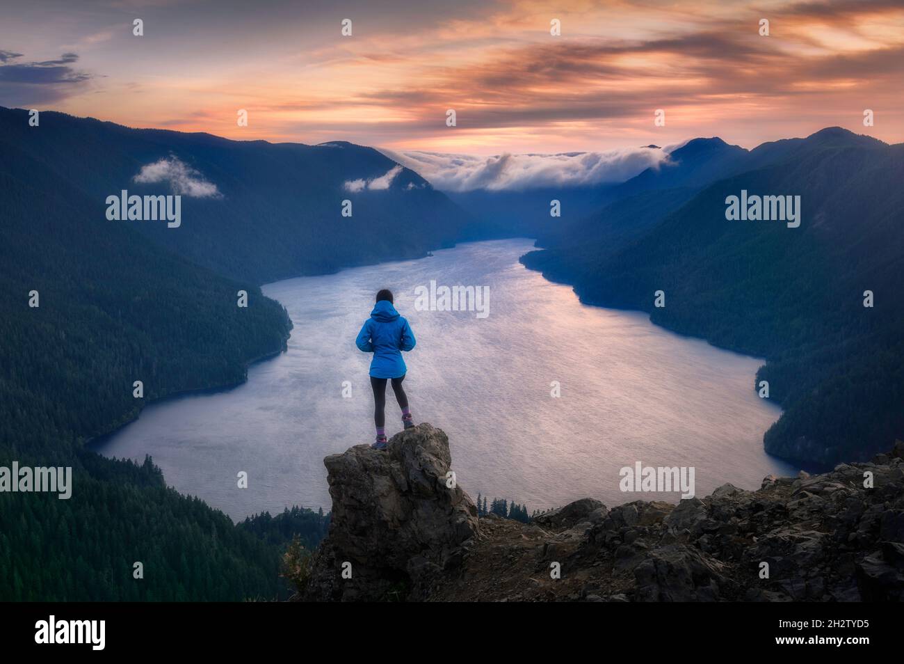 Hiker overlooking sunset from viewpoint of Mount Storm King, Olympic