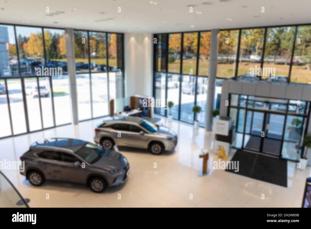 stylish modern car showroom, dealer office with new cars inside, blur