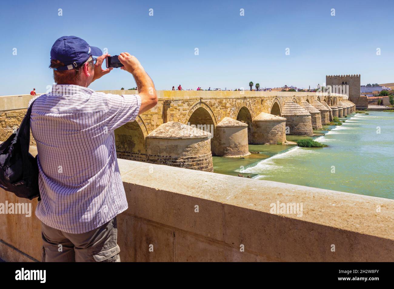 Visitor taking photo of the Roman Bridge across the Guadalquivier River, Cordoba, Cordoba Province, Andalusia, Spain.  The Historic Centre of Cordoba Stock Photo