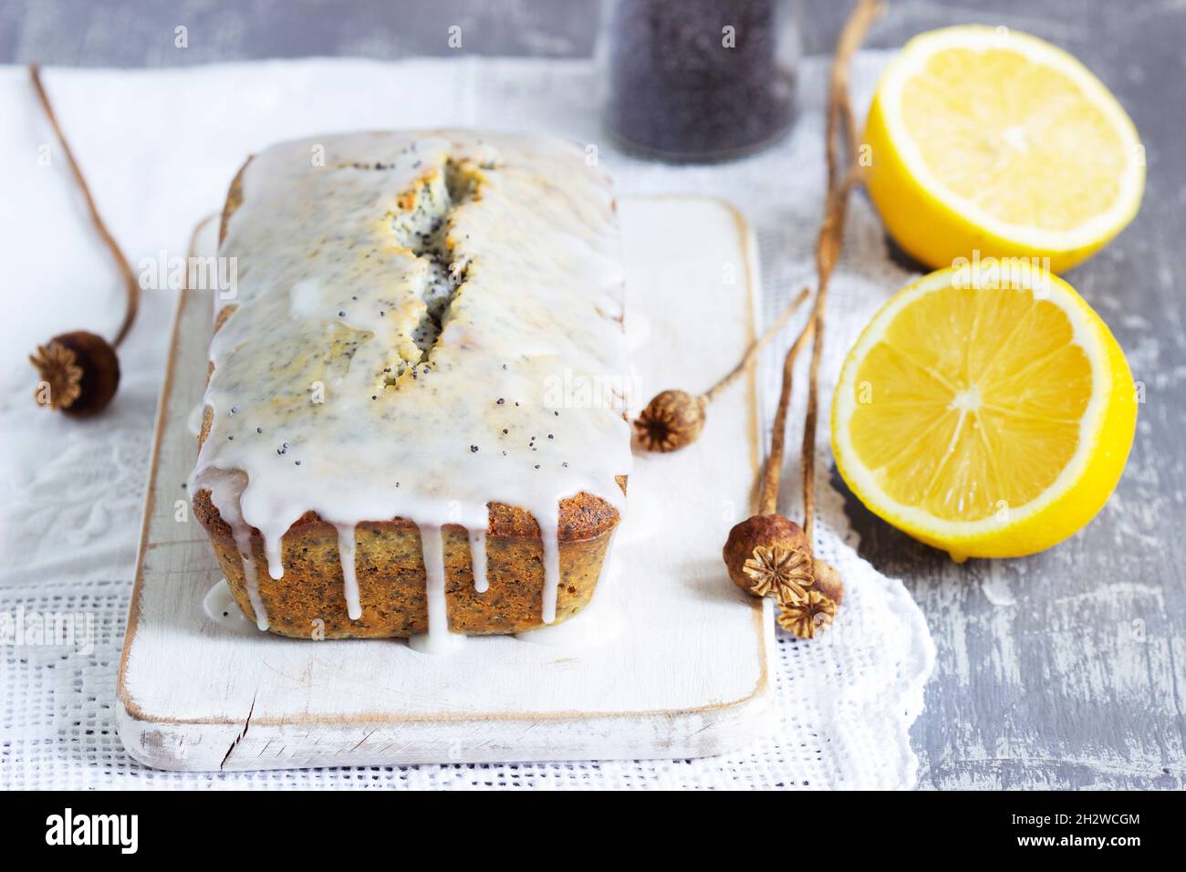 Lemon cake with poppy seeds, covered with glaze on a light background. Stock Photo