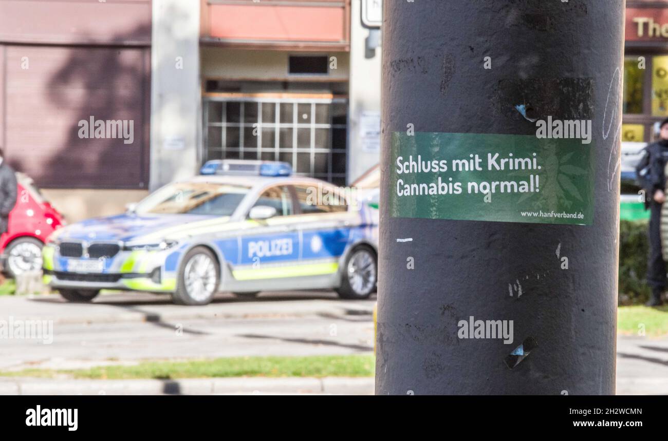 October 23, 2021, Munich, Bavaria, Germany: A sticker in Munich with police behind it that reads ''stop with the crime...Cannabis normal'' referring to a demand to end the criminalizing of cannabis usage in Germany- a topic that recently took front stage as the so-called Traffic-Light Coalition (Ampel-Koalition) may intend to bring decriminalization nearer. (Credit Image: © Sachelle Babbar/ZUMA Press Wire) Stock Photo
