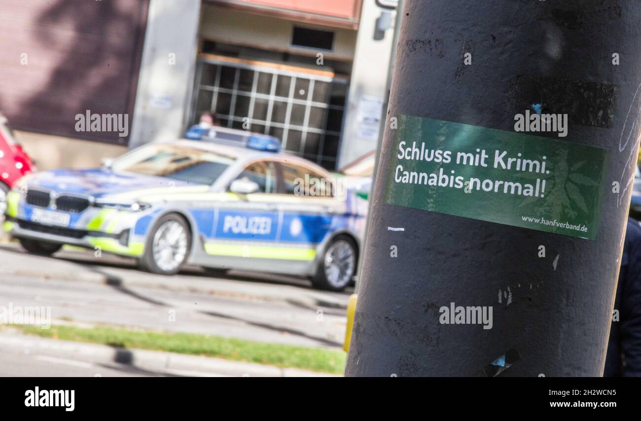 October 23, 2021, Munich, Bavaria, Germany: A sticker in Munich with police behind it that reads ''stop with the crime...Cannabis normal'' referring to a demand to end the criminalizing of cannabis usage in Germany- a topic that recently took front stage as the so-called Traffic-Light Coalition (Ampel-Koalition) may intend to bring decriminalization nearer. (Credit Image: © Sachelle Babbar/ZUMA Press Wire) Stock Photo