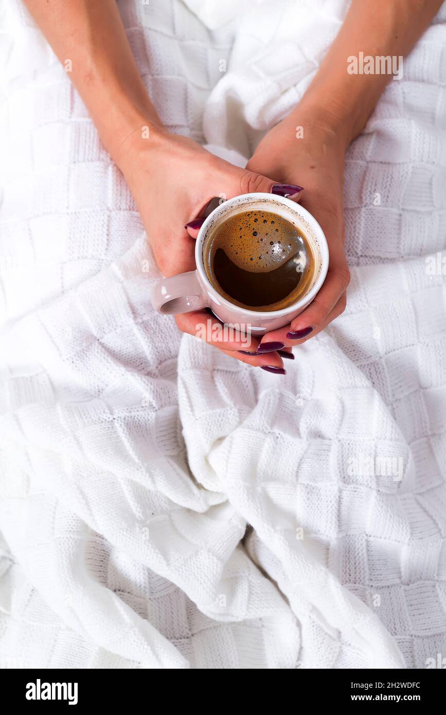 hands holding hot cup of coffee in bed Stock Photo - Alamy