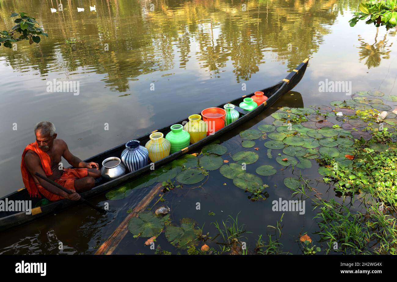 Potable water scarcity in Alappuzha,A boat full of drinking water sailing through the polluted Vembanad Lake in Kerala.Freshwater scarcity in Kuttanad Stock Photo