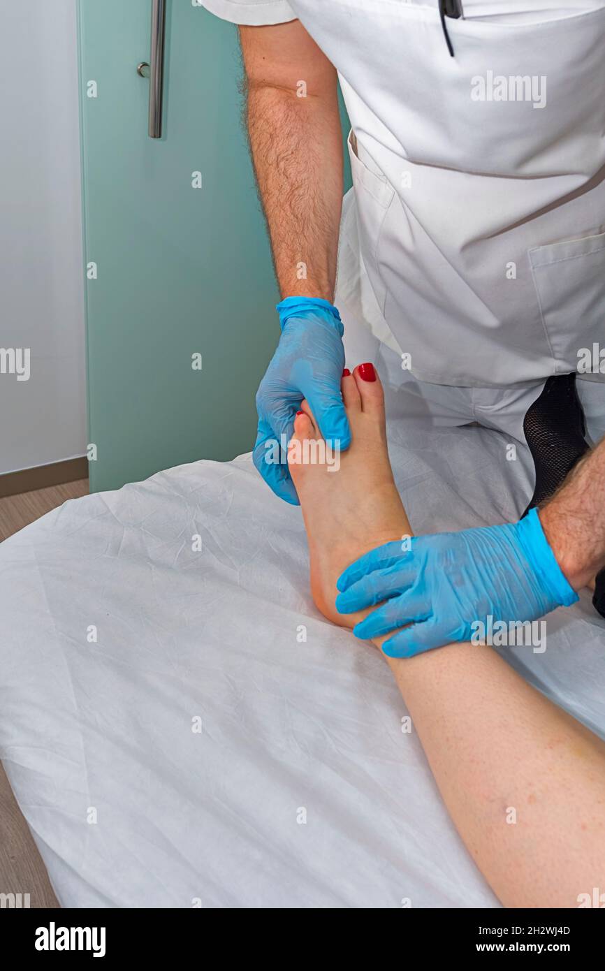 Doctor examines the foot of a girl. Stock Photo