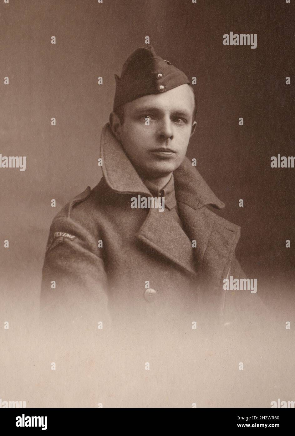 An antique sepia portrait photograph of a First World War Royal Flying Corps serviceman in uniform. He is wearing an RFC side cap and a great coat displaying a ‘Royal Flying Corps’ shoulder title. Stock Photo
