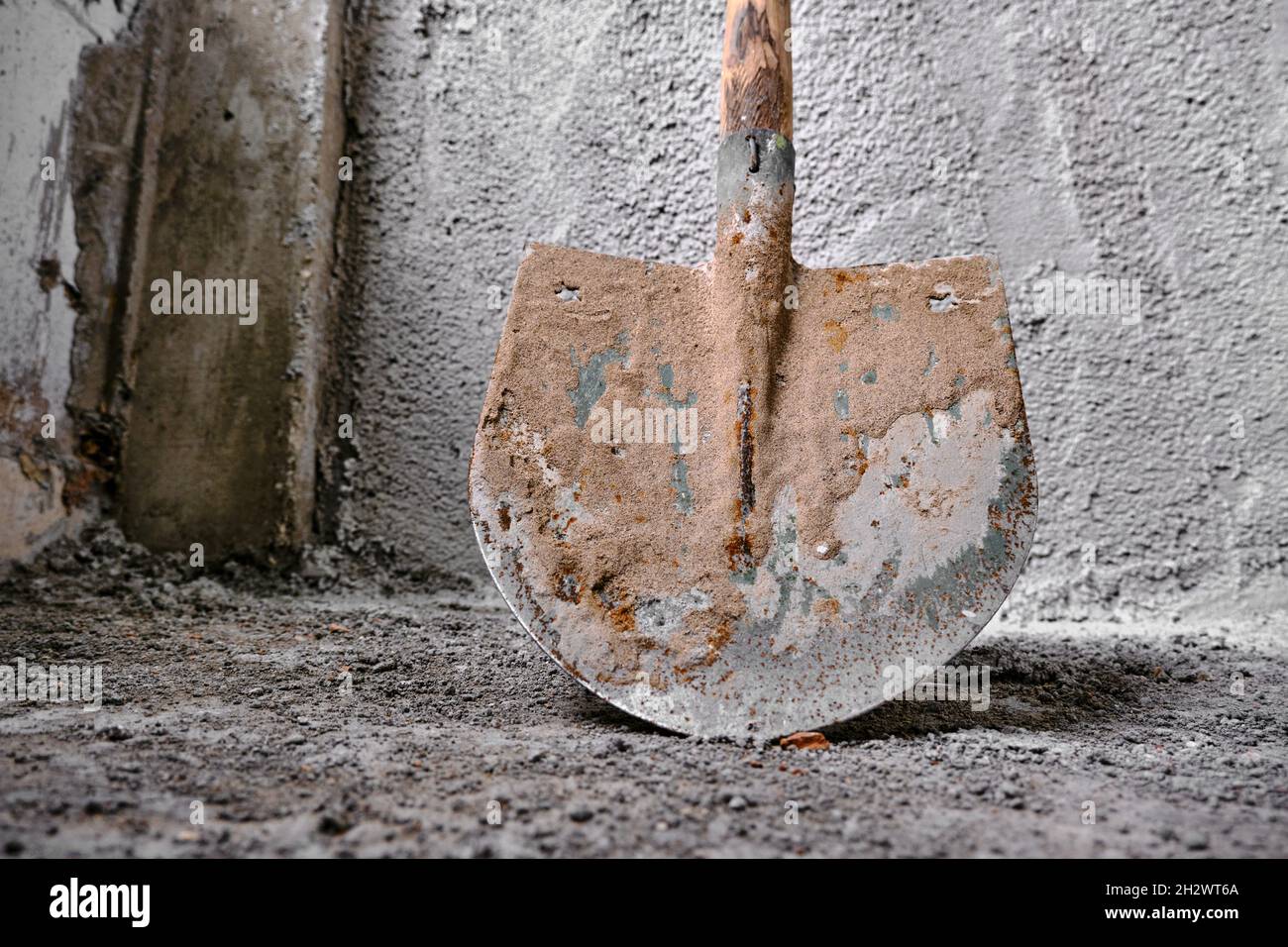 Construction works of plastering. photo taken low angle shovel in front of the recently made plastered wall by concrete. Stock Photo