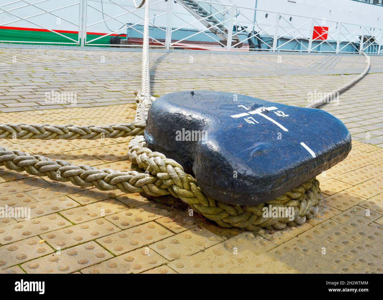 A single mooring device with coiled ropes keeps the ship on the dock. close-up Stock Photo